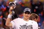 INDIANAPOLIS, IN - FEBRUARY 05:  Eli Manning #10 of the New York Giants celebrates with the Vince Lombardi trophy after the Giants won 21-17 against the New England Patriots during Super Bowl XLVI at Lucas Oil Stadium on February 5, 2012 in Indianapolis, Indiana.  (Photo by Rob Carr/Getty Images)