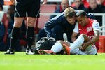 LONDON, ENGLAND - APRIL 21:  Theo Walcott of Arsenal receives treatment watched by referee Mike Dean during the Barclays Premier League match between Arsenal and Chelsea at Emirates Stadium on April 21, 2012 in London, England.  (Photo by Mike Hewitt/Getty Images)