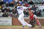 CHICAGO, IL - APRIL 20:   Starlin Castro #13 of the Chicago Cubs (L) hits a deep fly ball as catcher Devin Mesoraco #39 of the Cincinnati Reds watches during the third inning at Wrigley Field on April 20, 2012 in Chicago, Illinois. Left fielder Chris Heisey #28 dropped the ball and David DeJesus #9 of the Chicago Cubs scored on the error. The Reds defeated the Cubs 9-4.  (Photo by Brian Kersey/Getty Images)