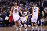 OAKLAND, CA - FEBRUARY 20:  David Lee #10 (L), Nate Robinson #2, and Stephen Curry #30 of the Golden State Warriors celebrate after Robinson made a basket in the fourth quarter of their game against the Los Angeles Clippers at Oracle Arena on February 20, 2012 in Oakland, California.  NOTE TO USER: User expressly acknowledges and agrees that, by downloading and or using this photograph, User is consenting to the terms and conditions of the Getty Images License Agreement.  (Photo by Ezra Shaw/Getty Images)