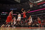 CHICAGO, IL - MARCH 12:  Derrick Rose #1 of the Chicago Bulls goes up for a dunk between Baron Davis #85 and Tyson Chandler #6 of the New York Knicks on his way to a game-high 32 points at the United Center on March 12, 2012 in Chicago, Illinois. The Bulls defeated the Knicks 104-99. NOTE TO USER: User expressly acknowledges and agrees that, by downloading and or using this photograph, User is consenting to the terms and conditions of the Getty Images License Agreement.  (Photo by Jonathan Daniel/Getty Images)