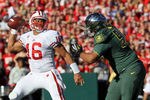 PASADENA, CA - JANUARY 02:  Quarterback Russell Wilson #16 of the Wisconsin Badgers passes the ball as Ricky Heimuli #90 of the Oregon Ducks rushes in at the 98th Rose Bowl Game on January 2, 2012 in Pasadena, California.  (Photo by Stephen Dunn/Getty Images)