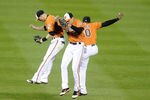 BALTIMORE, MD - APRIL 28:  Nolan Reimold #14, Ryan Flaherty #3 and Adam Jones #10 of the Baltimore Orioles celebrate a win after a baseball game against the Oakland Athletics at Oriole Park at Camden Yards on April 28, 2012 in Baltimore, Maryland.  The Orioles won 10-1.  (Photo by Mitchell Layton/Getty Images)