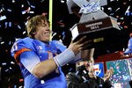 LAS VEGAS, NV - DECEMBER 22:  Quarterback Kellen Moore #11 of the Boise State Broncos holds up the trophy after defeating the Arizona State Sun Devils 56-24 in the MAACO Bowl Las Vegas at Sam Boyd Stadium December 22, 2011 in Las Vegas, Nevada.  (Photo by Ethan Miller/Getty Images)