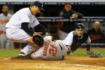 NEW YORK, NY - APRIL 30:  Hiroki Kuroda #18 of the New York Yankees tags out Nick Markakis #21 of the Baltimore Orioles who tried to steal home off of a wild pitch as Russell Martin #55 of the New York Yankees who flipped the ball to Hiroki looks on during their game on April 30, 2012 at Yankee Stadium in the Bronx borough of New York City.  (Photo by Al Bello/Getty Images)