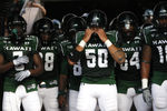HONOLULU - SEPTEMBER 02: Mana Lolotai #50 of the University of Hawaii Warriors checks his helmet before the Warriors take the field in their season opener against the University of Southern California Trojans at Aloha Stadium September 2, 2010 in Honolulu, Hawaii. (Photo by Kent Nishimura/Getty Images)