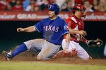 ANAHEIM, CA - SEPTEMBER 27:  Ian Kinsler #5 of the Texas Rangers slides safely past catcher Hank Conger #16 of the Los Angeles Angels of Anaheim and scores a run in the fourth inning at Angel Stadium of Anaheim on September 27, 2011 in Anaheim, California.  (Photo by Jeff Gross/Getty Images)