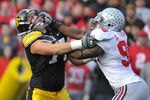 IOWA CITY, IA - NOVEMBER 20:  Quarterback Ricky Stanzi #12 of the University of Iowa Hawkeyes throws under pressure from defensive lineman Solomon Thomas #98 of the Ohio State Buckeyes as offensive lineman Riley Reiff #77 defends during the first half of play at Kinnick Stadium on November 20, 2010 in Iowa City, Iowa. Ohio State won 20-17 over Iowa. (Photo by David Purdy/Getty Images)