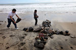 OCEANSIDE, CA - MAY 2:  Wellwishers Jimmy Garcia (L) and Adam Alvarado create a cross made out of stones across the street from Junior Seau's beach home May 2, 2012 in Oceanside, California. Seau, who played for various NFL teams including the San Diego Chargers, Miami Dolphins and New England Patriots was found dead by his girlfriend in his home with a gunshot wound to his chest in an apparent suicide.  (Photo by Sandy Huffaker/Getty Images)