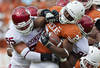 DALLAS, TX - OCTOBER 8:   Malcolm Brown #28 of the Texas Longhorns is tackled by the defense of the Oklahoma Sooners at the Cotton Bowl on October 8, 2011 in Dallas, Texas.  The Sooners defeated the Longhorns 55 to 17.  (Photo by Wesley Hitt/Getty Images)