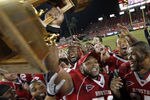 HOUSTON - OCTOBER 27:  Chris Thompson #70 of the Houston Cougars along with his teammates hold up the Bayou Bucket after they defeated the Rice Owls 73-34 at Robertson Stadium on October 27, 2011 in Houston, Texas.  (Photo by Bob Levey/Getty Images)