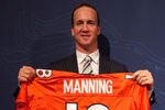 ENGLEWOOD, CO - MARCH 20:  Quarterback Peyton Manning poses with his uniform after the news conference announcing his contract with the Denver Broncos in the team meeting room at the Paul D. Bowlen Memorial Broncos Centre on March 20, 2012 in Englewood, Colorado. Manning, entering his 15th NFL season, was released by the Indianapolis Colts on March 7, 2012, where he had played his whole career. It has been reported that Manning will sign a five-year, $96 million offer.  (Photo by Doug Pensinger/Getty Images)