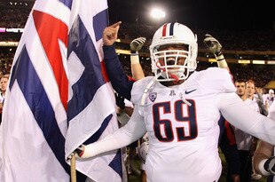 TEMPE, AZ - NOVEMBER 19:   Offensive lineman Eric Bender-Ramsay #69 of the Arizona Wildcats celebrates with a flag after defeating the Arizona State Sun Devils in the college football game at Sun Devil Stadium on November 19, 2011 in Tempe, Arizona. The Wildcats defeated the Sun Devils 31-27.  (Photo by Christian Petersen/Getty Images)