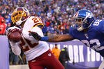 EAST RUTHERFORD, NJ - DECEMBER 18:   Josh Wilson #26 of the Washington Redskins catches aninterception against  Mario Manningham #82 of the New York Giants during their game at MetLife Stadium on December 18, 2011 in East Rutherford, New Jersey.  (Photo by Al Bello/Getty Images)