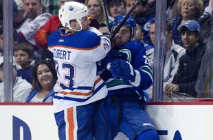 VANCOUVER, CANADA - APRIL 7: Chris Higgins #20 of the Vancouver Canucks gets hit by Colten Teubert #33 of the Edmonton Oilers during the second period in NHL action on April 07, 2012 at Rogers Arena in Vancouver, British Columbia, Canada.  (Photo by Rich Lam/Getty Images)