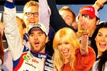 CHARLOTTE, NC - MAY 19:  Jimmie Johnson (L), driver of the #48 Lowe's Patriotic Chevrolet, poses in victory lane with wife Chandra (C), actress Angie Harmon (R), and her husband/former football player Jason Sehorn (Top) after winning the NASCAR Sprint All-Star Race at Charlotte Motor Speedway on May 19, 2012 in Charlotte, North Carolina.  (Photo by Jamey Price/Getty Images for NASCAR)