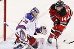 NEWARK, NJ - MAY 19:  Henrik Lundqvist #30 of the New York Rangers defends against Adam Henrique #14 of the New Jersey Devils in Game Three of the Eastern Conference Final during the 2012 NHL Stanley Cup Playoffs at the Prudential Center on May 19, 2012 in Newark, New Jersey.  (Photo by Jim McIsaac/Getty Images)