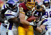 LANDOVER, MD - DECEMBER 24: Tight end Logan Paulsen #82 of the Washington Redskins is pulled down by linebacker E.J. Henderson #56 of the Minnesota Vikings and linebacker Chad Greenway #52 of the Minnesota Vikings in the fourth quarter at FedEx Field on December 24, 2011 in Landover, Maryland. The Minnesota Vikings won, 33-26. (Photo by Patrick Smith/Getty Images)