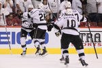 GLENDALE, AZ - MAY 22:  Dustin Penner #25 of the Los Angeles Kings celebrates with teammates Slava Voynov #26, Jeff Carter #77 and Mike Richards #10 after Penner scores the game-winning goal in overtime as the Kings defeat the Phoenix Coyotes 4-3 in Game Five of the Western Conference Final during the 2012 NHL Stanley Cup Playoffs at Jobing.com Arena on May 22, 2012 in Phoenix, Arizona.  (Photo by Jeff Gross/Getty Images)