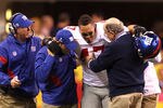 INDIANAPOLIS, IN - FEBRUARY 05:  Tight end Travis Beckum #47 of the New York Giants gets assisted off the field after injuring his ACL during the game against the New England Patriots in the second quarter during Super Bowl XLVI at Lucas Oil Stadium on February 5, 2012 in Indianapolis, Indiana.  (Photo by Al Bello/Getty Images)