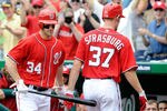 WASHINGTON, DC - MAY 20:  Stephen Strasburg #37 of the Washington Nationals is congratulated by Bryce Harper #34 after hitting his first career home run in the fourth inning against the Baltimore Orioles during interleague play at Nationals Park on May 20, 2012 in Washington, DC.  (Photo by Greg Fiume/Getty Images)
