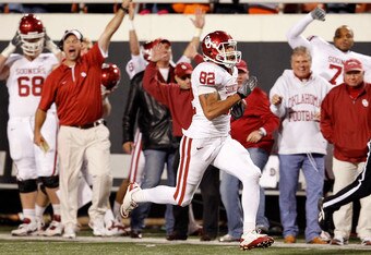STILLWATER, OK - NOVEMBER 27:  Tightend James Hanna #82 of the Oklahoma Sooners beats out cornerback Andrew McGee #6 of the Oklahoma State Cowboys to score at Boone Pickens Stadium on November 27, 2010 in Stillwater, Oklahoma.  The Sooners beat the Cowboys 47-41.  (Photo by Tom Pennington/Getty Images)
