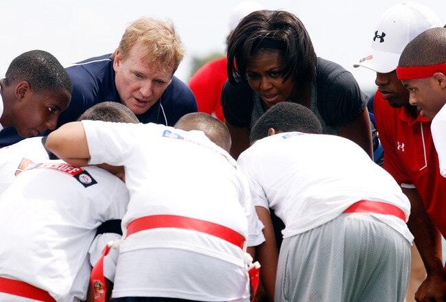 NEW ORLEANS - SEPTEMBER 08:  U.S. first lady Michelle Obama and NFL commissioner Roger Goodell  listen to their team in the huddle during the NFL�s Play 60 campaign to fight childhood obesity at Brock Elementary School September 8, 2010 in New Orleans, Louisiana. Obama joined NFL Commissioner Roger Goodell and former NFL coach Tony Dungy to promote the Play 60 campaign and the NFL's newest efforts to support Let's Move! (Photo by Chris Graythen/Getty Images)