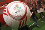 BERLIN, GERMANY - SEPTEMBER 02:  A visitor clowns with a giant soccer ball emblazened with the lgo of the Euro 2012 EUFA Cup football championships on display at the Sharp stand at the IFA 2011 consumer technology trade fair on the first day of the fair's official opening on September 2, 2011 in Berlin, Germany. The IFA 2011 will be open to the public from September 2-7.  (Photo by Sean Gallup/Getty Images)