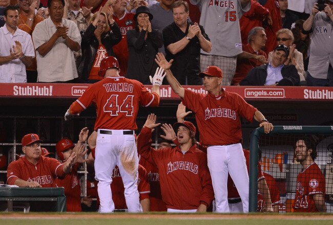 ANAHEIM, CA - MAY 29:  Mark Trumbo #44 of the Los Angeles Angels celebrates his homerun with Mike Scioscia, C.J. Wilson #33,Rob Picciolo #9 and Dan Haren #24 for a 4-1 lead over the New York Yankees during the sixth inning at Angel Stadium of Anaheim on May 29, 2012 in Anaheim, California.  (Photo by Harry How/Getty Images)