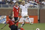DETROIT, MI - JUNE 7: Michael Bradley #4 of the United States tries to get the ball by jumping over the leg of Atiba Hutchinson #13 of Canada during the 2011 Gold Cup  at Ford Field on June 7, 2011 in Detroit, Michigan. The United States won the game 2-0. (Photo by Gregory Shamus/Getty Images)