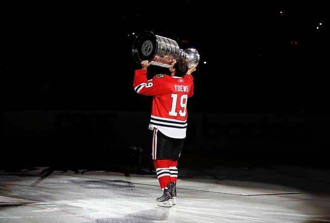 CHICAGO - OCTOBER 09: Jonathan Toews #19 of the Chicago Blackhawks kisses the Stanley Cup trophy as he skates across the ice in a ceremony before the Blackhawks season home opening game against the Detroit Red Wings at the United Center on October 9, 2010
