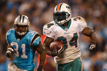 CHARLOTTE, NC - NOVEMBER 19:  Ricky Williams #34 of the Miami Dolphins runs away from Richard Marshall #31 of the Carolina Panthers during their game at Bank of America Stadium on November 19, 2009 in Charlotte, North Carolina.  (Photo by Streeter Lecka/G