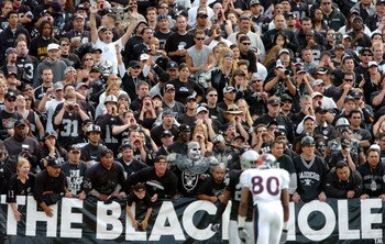 OAKLAND, CA - OCTOBER 17:  Fans in the black hole cheer as Rod Smith #80 of the Denver Broncos and Charles Woodson #24 of the Oakland Raiders line up at scrimmage at the Network Associates Coliseum on October 17, 2004 in Oakland, California.  (Photo by Tr