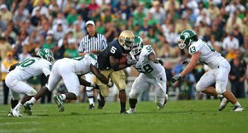 SOUTH BEND, IN - SETPEMBER 19: Armando Allen #5 of the Notre Dame Fighting Irish runs against (L-R) Roderick Jenrette #40, Greg Jones #53, Trevor Anderson #58 and Eric Gordon #43 of the Michigan State Spartans on September 19, 2009 at Notre Dame Stadium i