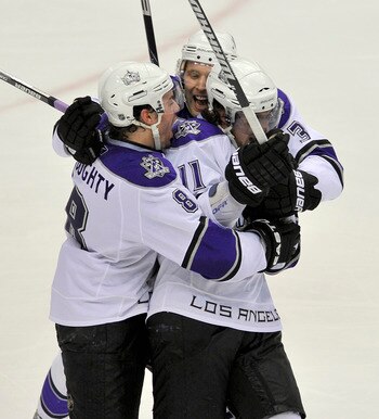 VANCOUVER, CANADA - APRIL 17:  Anze Kopitar #11 of the Los Angeles Kings is congratulated by teammates Drew Doughty and Jack Johnson after scoring the game winning goal against the Vancouver Canucks during the overtime period in Game Two of the Western Co