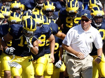 ANN ARBOR, MI - AUGUST 30:  Head coach Rich Rodriguez of the Michigan Wolverines leads his team onto the field next to Morgan Trent #14 prior to playing the Utah Utes on August 30, 2008 at Michigan Stadium in Ann Arbor, Michigan.  (Photo by Gregory Shamus