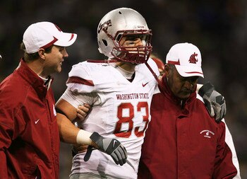 SEATTLE - NOVEMBER 28:  Tight end Zach Tatman #83 of the Washington State Cougars is helped off the field after being injured against the Washington Huskies on November 28, 2009 at Husky Stadium in Seattle, Washington. The Huskies defeated the Cougars 30-