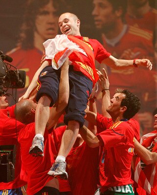 MADRID, SPAIN - JULY 12: Andres Iniesta of the Spanish national football team is held aloft by his teammates during the Spanish team's victory parade following their  2010 FIFA World Cup victory on July 12, 2010 in Madrid, Spain.  (Photo by Daniel Sastre/