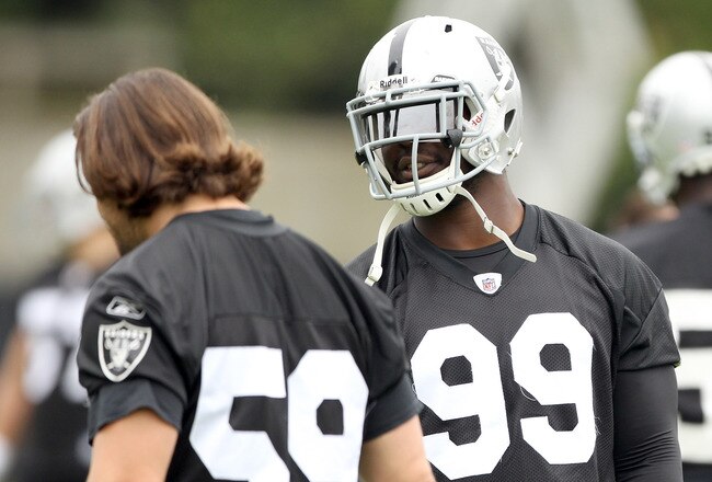 NAPA, CA - AUGUST 01:  Lamarr Houston #99 of the Oakland Raiders talks to Jon Condo #59 during the Raiders training camp at their Napa Valley Training Complex on August 1, 2010 in Napa, California.  (Photo by Ezra Shaw/Getty Images)
