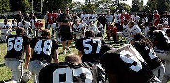 Head coach Tom Cable addresses the team at the end of practice.