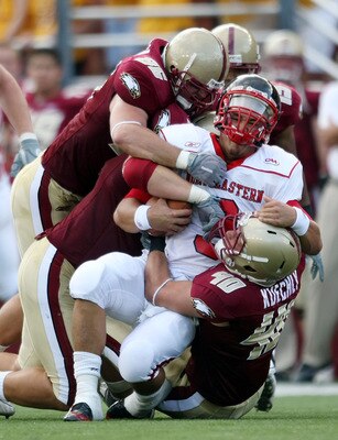 CHESTNUT HILL, MA - SEPTEMBER 05:  Matt Carroll #3 of the Northeastern Huskies is tackled by Dillon Quinn #92,Kaleb Ramsey #96 and Luke Kuechly #40  of the Boston College Eagles on September 5, 2009 at Alumni Stadium in Chestnut Hill, Massachusetts.  (Pho