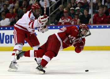 WASHINGTON - APRIL 11:  Justin Mercier #16 of the Miami Red Hawks takes a shot as he is shoved by Colby Cohen #25 of the Boston Terriers during the NCAA Men's Frozen Four Championship game on April 11, 2009 at the Verizon Center in Washington, DC.  (Photo