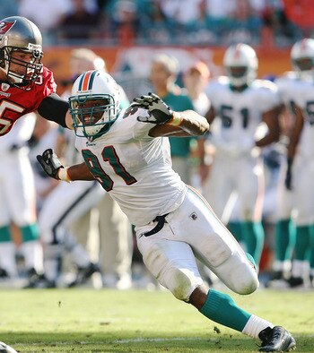 MIAMI GARDENS, FL - NOVEMBER 15:  Tackle Jeremy Trueblood #65 of the Tampa Bay Buccaneers tries to keep linebcker Cameron Wake #91 of the Miami Dolphins from getting to quarterback Josh Freeman #5 at Land Shark Stadium on November 15, 2009 in Miami Garden