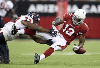 GLENDALE, AZ - AUGUST 14:  Wide receiver Andre Roberts #12 of the Arizona Cardinals loses the ball as he is hit by Troy Nolan #33 of the Houston Texans during preseason NFL game at the University of Phoenix Stadium on August 14, 2010 in Glendale, Arizona.