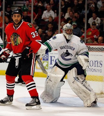 CHICAGO - MAY 09: Dustin Byfuglien #33 of the Chicago Blackhawks places himself between Sami Salo #6 and Roberto Luongo #1 of the Vancouver Canucks in Game Five of the Western Conference Semifinals during the 2010 NHL Stanley Cup Playoffs at United Center
