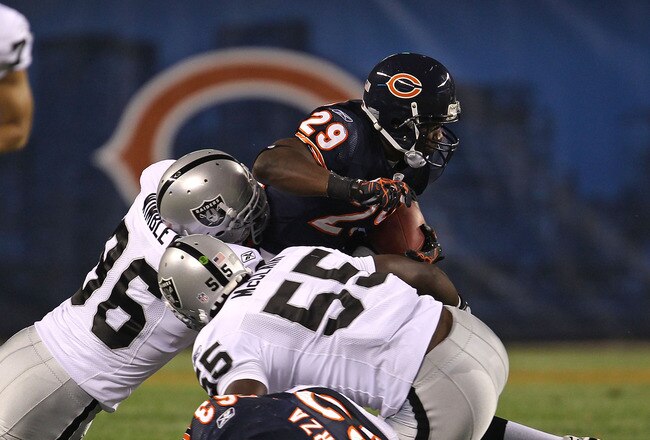 CHICAGO - AUGUST 21: Chester Taylor #29 of the Chicago Bears tries to break away from Kamerion Wimbley #96 and Rolando McClain #55 of the Oakland Raiders and past teammate Roberto Garza #63 during a preseason game at Soldier Field on August 21, 2010 in Ch