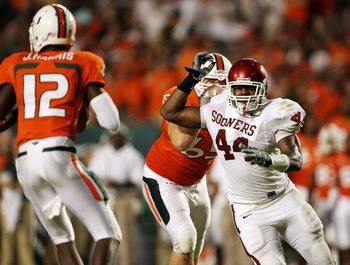 MIAMI GARDENS, FL - OCTOBER 03:  Quarterback Jacory Harris #12 of the Miami Hurricanes drops back to pass as defensive end Jeremy Beal #44 of the Oklahoma Sooners gets past offensive lineman Matt Pipho #65 at Land Shark Stadium on October 3, 2009 in Miami