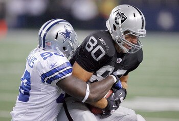 ARLINGTON, TX - AUGUST 12:  Zach Miller #80 of the Oakland Raiders carries the ball against Jason Williams #58 of the Dallas Cowboys during the preseason game at Dallas Cowboys Stadium on August 12, 2010 in Arlington, Texas.  The Raiders beat the Cowboys