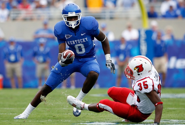 LEXINGTON, KY - SEPTEMBER 19:  Chris Matthews #8 of the Kentucky Wildcats runs with the ball while defended by Anthony Conner #35 of the Louisville Cardinals during the game at Commonwealth Stadium on September 19, 2009 in Lexington, Kentucky.  (Photo by