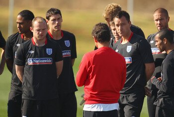 RUSTENBURG, SOUTH AFRICA - JUNE 24:  John Terry looks on as England coach Fabio Capello speaks to his team at an England training session during the FIFA 2010 World Cup at the Royal Bafokeng Sports Campus on June 24, 2010 in Rustenburg, South Africa.  (Ph